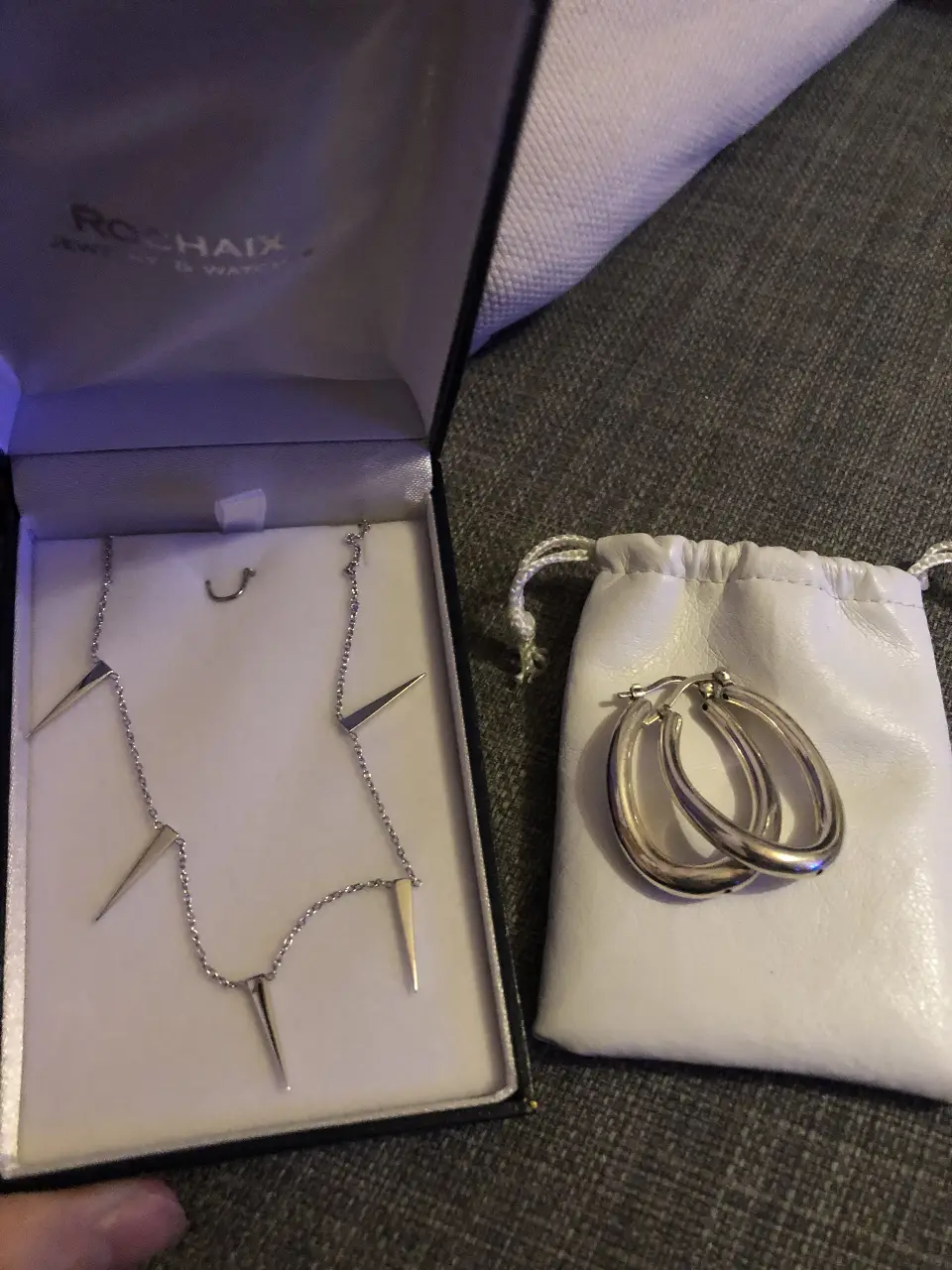 Juego de aros argolla de plata y collar con dijes triangulares de plata. Ideal para un look elegante y moderno.