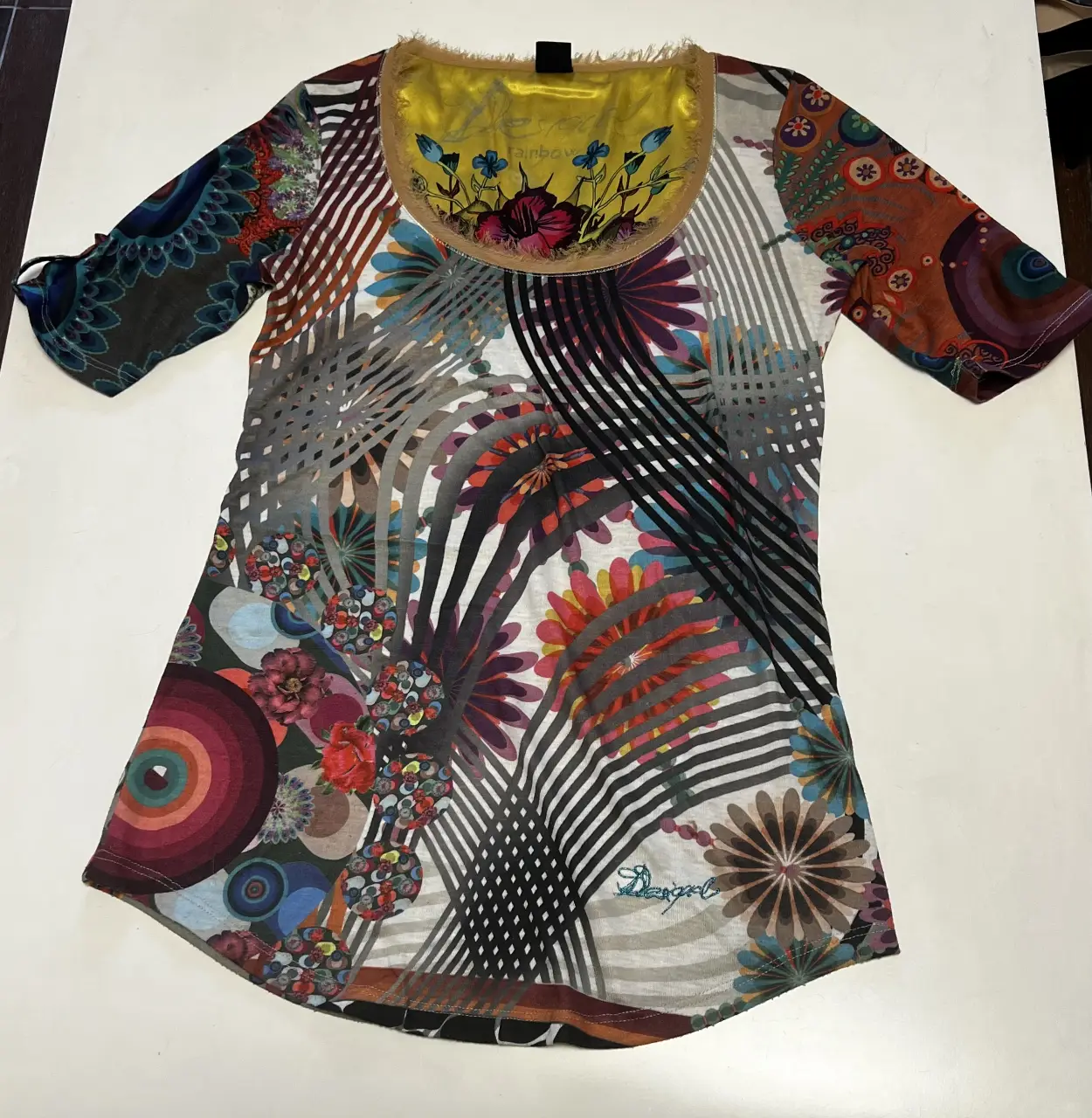 Blusa estampada de mujer, con diseño floral y geométrico. Cuello redondo con detalle de flecos y mangas 3/4. Ideal para un look casual y bohemio.