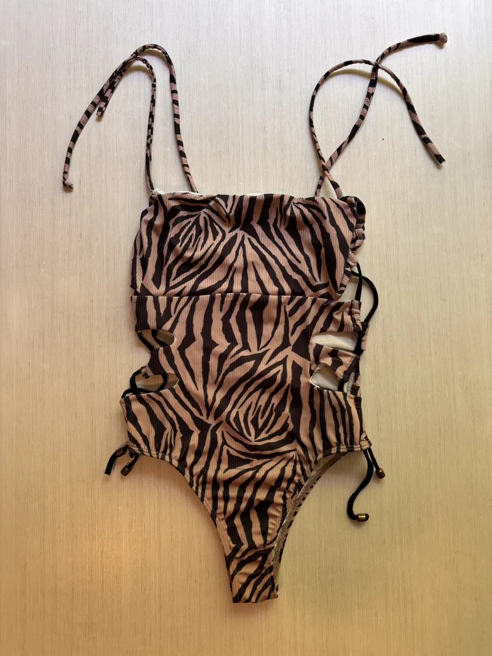 ¡Impresionante traje de baño de una pieza con estampa de cebra! Diseño audaz con recortes laterales y cordones ajustables para un calce perfecto. Ideal para lucirte en la playa o la pileta con mucho estilo.