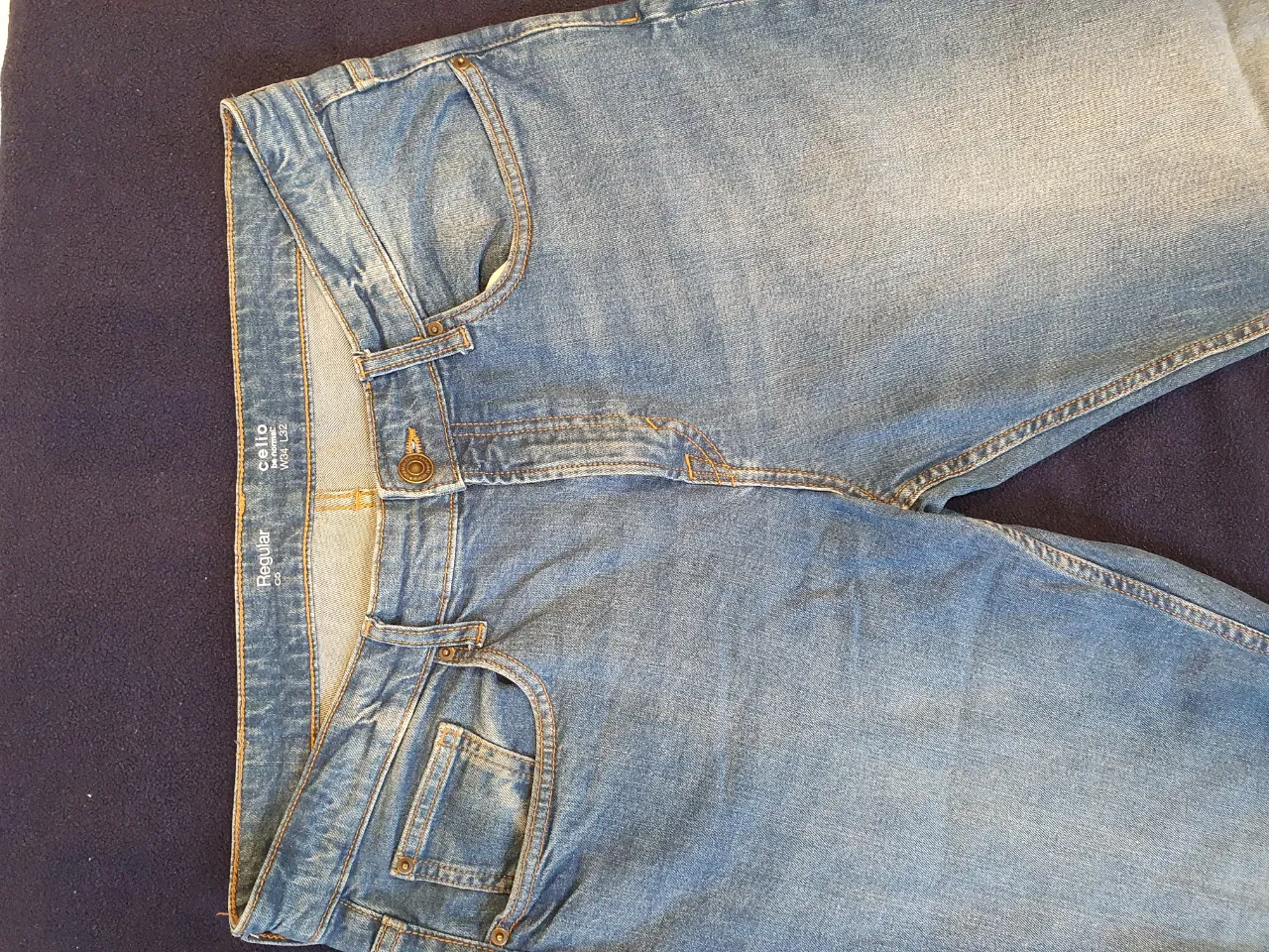Jeans rectos de hombre, color azul claro, con diseño clásico de cinco bolsillos. Ideal para un look casual y versátil.