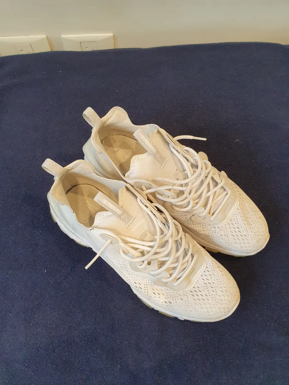 Zapatillas Nike React blancas de hombre, ideales para uso diario. Diseño moderno y cómodo.