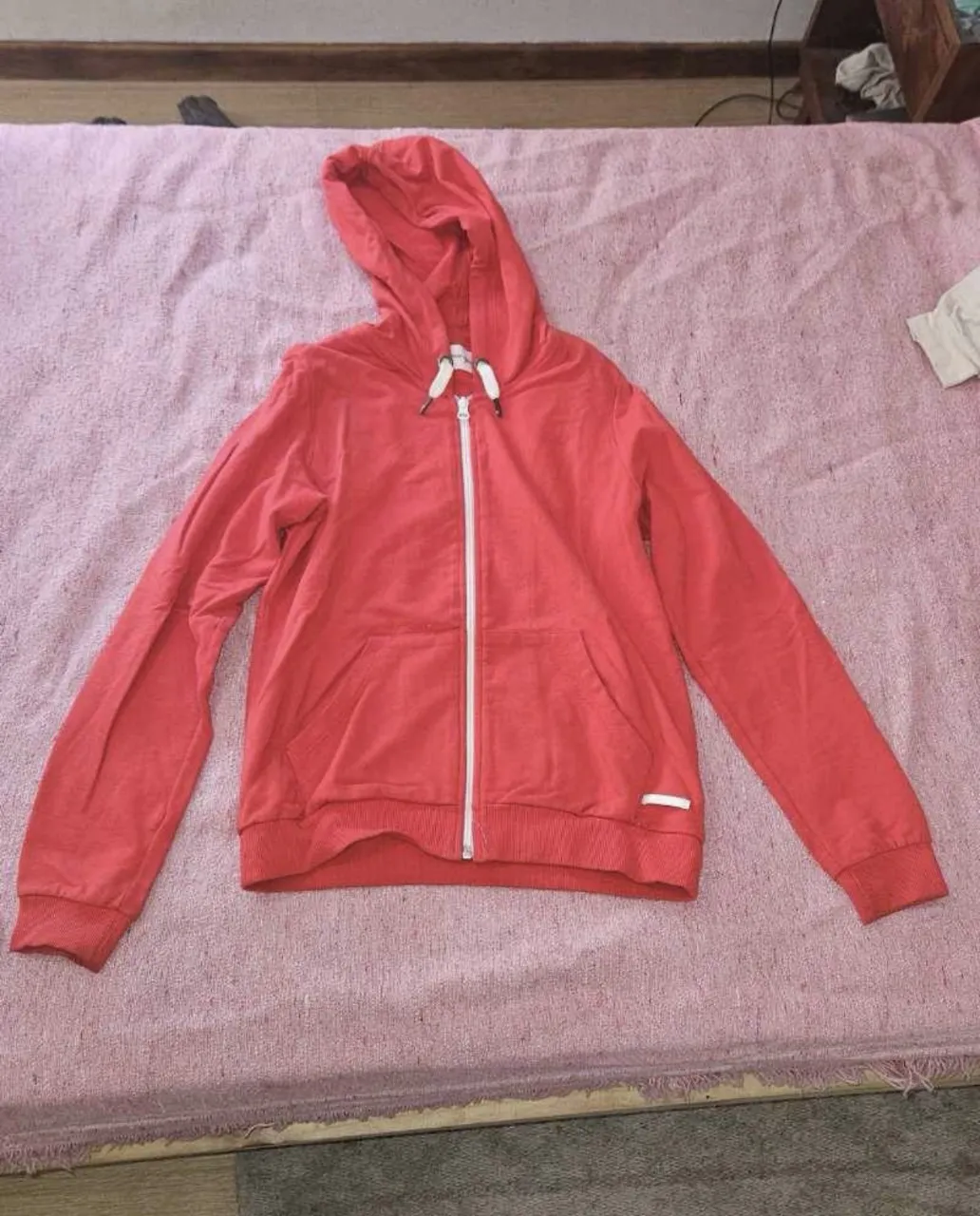 Buzo con capucha y cierre completo, ideal para un look casual y cómodo. Perfecto para el día a día o para actividades al aire libre.