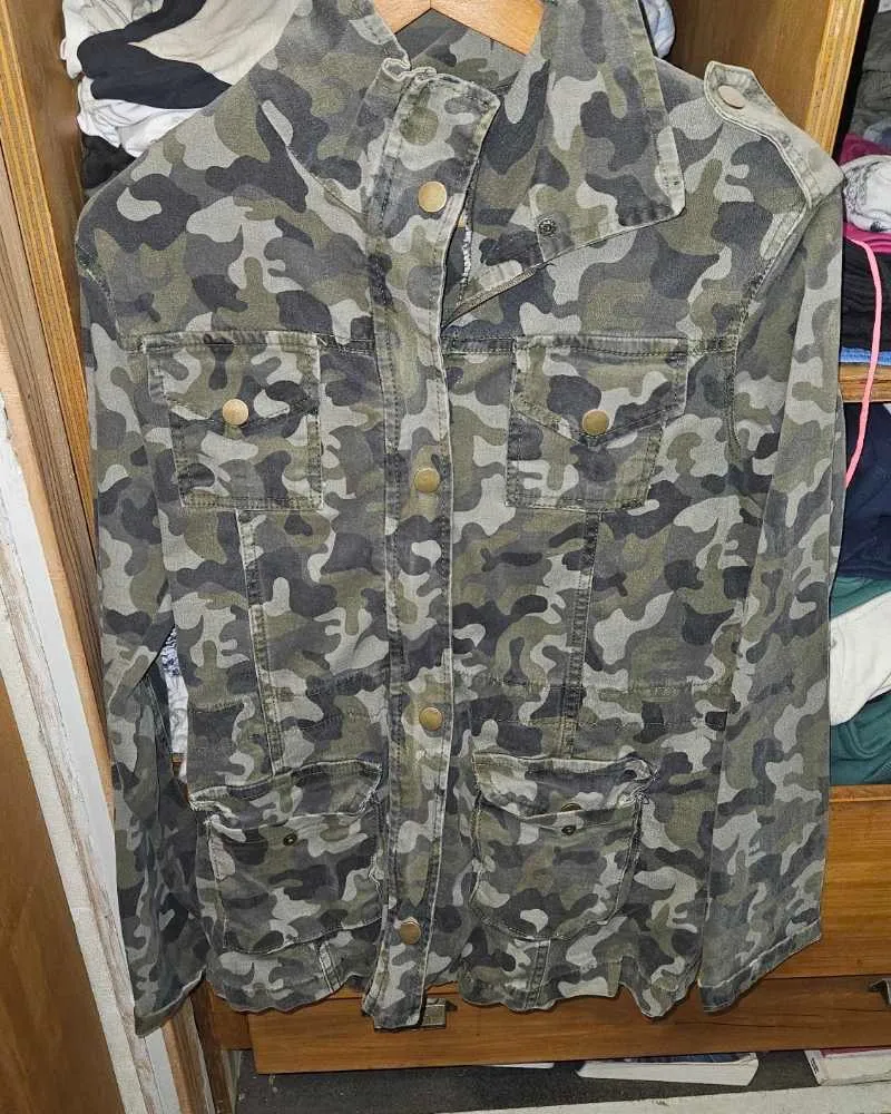 Campera de jean estilo militar con estampa camuflada. Posee múltiples bolsillos frontales y cierre.