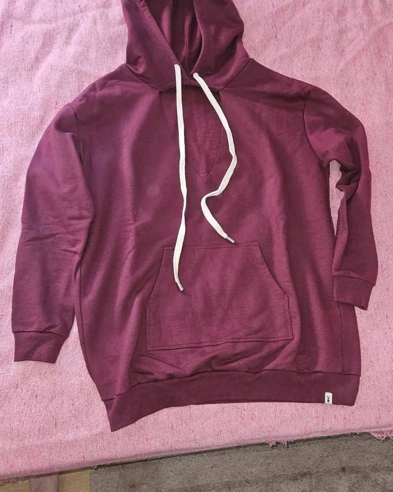 Hoodie de algodón color bordo con bolsillo canguro y cordones blancos. Diseño moderno y cómodo, ideal para el día a día.
