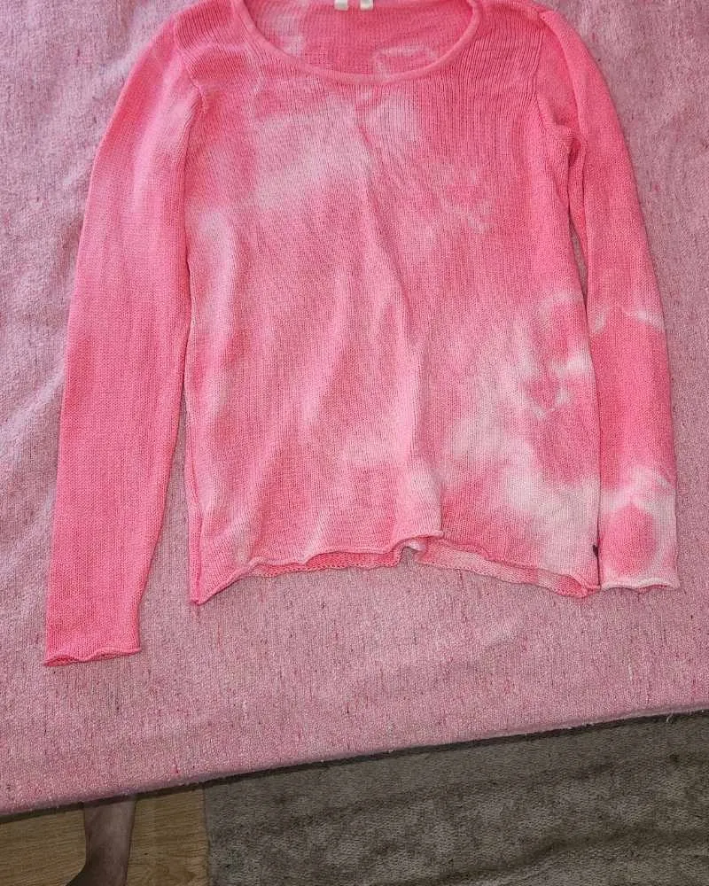 Sweater tejido de hilo con estampa tie-dye en tonos rosas y blancos. Manga larga y cuello redondo. Ideal para un look casual y relajado.