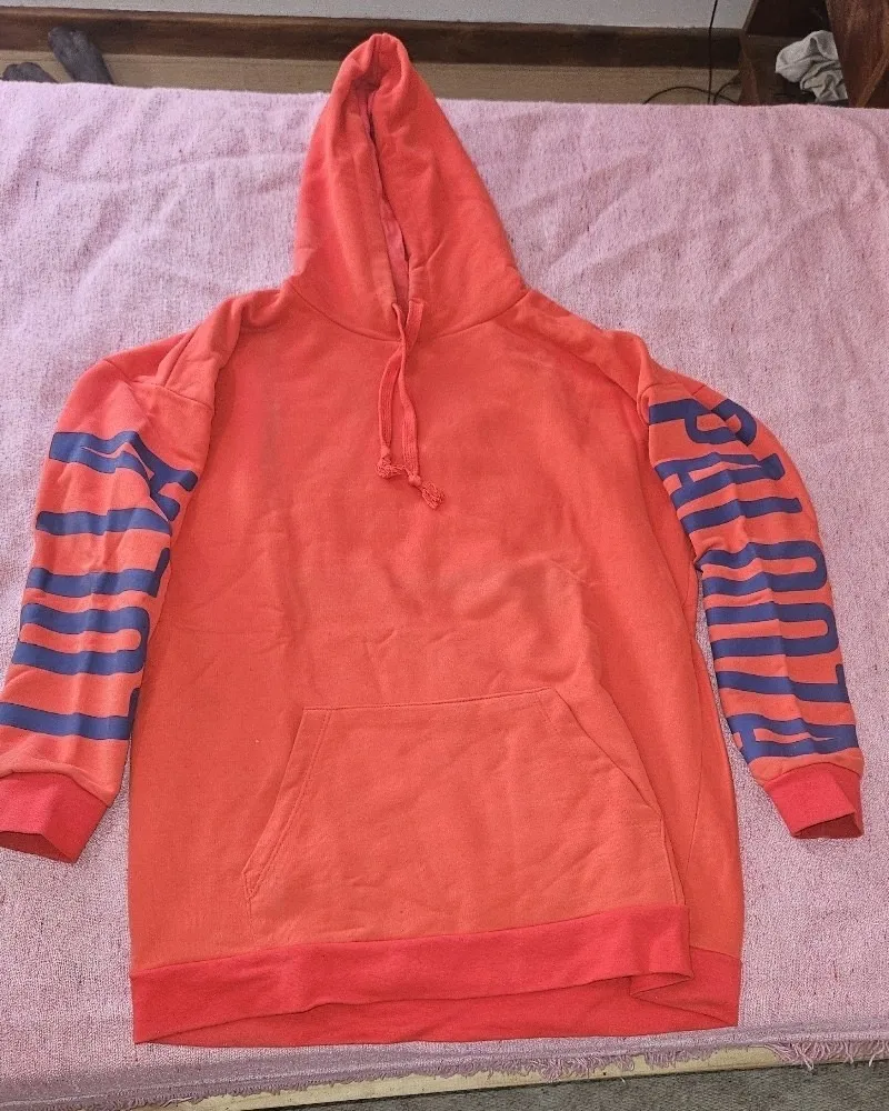 Buzo canguro naranja con mangas a rayas azules y estampa de Lollapalooza. Ideal para un look urbano y canchero.