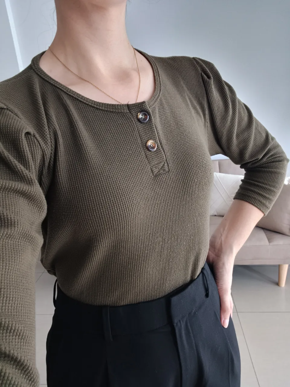 Remera LIBRANOS DEL MAL manga 3/4 de color verde musgo con cuello redondo y dos botones en la parte superior. Posee hombros con un leve fruncido. Tela de algodón waffle.