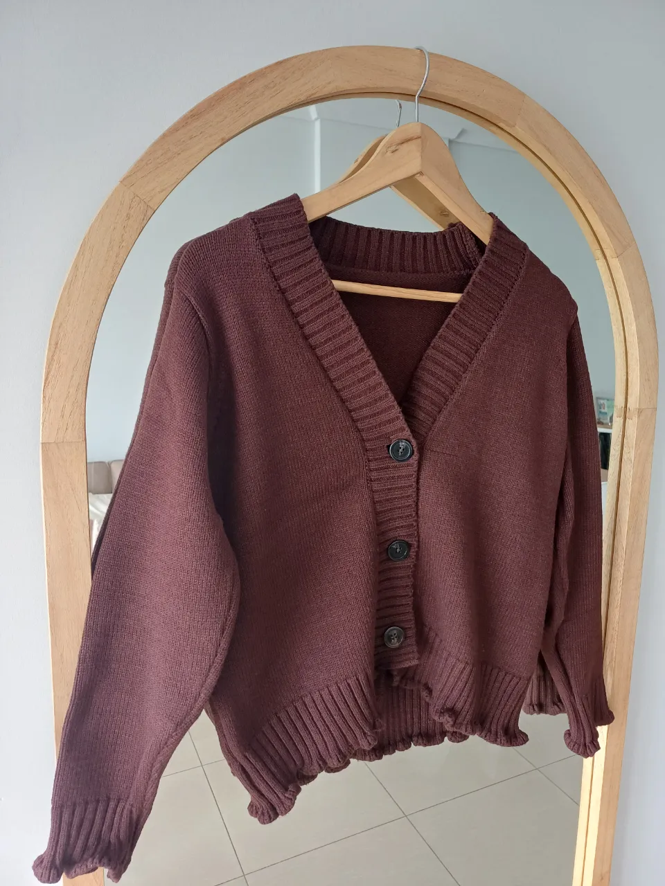 Cardigan AMELIA BAIRES, de bremer  (tejido de punto grueso) color marrón. Posee cuello en V y botones al frente. El borde inferior y las mangas tienen un detalle ondulado.
● Medidas: contorno de busto abotonado 96cm, largo 52cm.
● Referencias: mi busto mide 85cm y mi cintura 70cm.