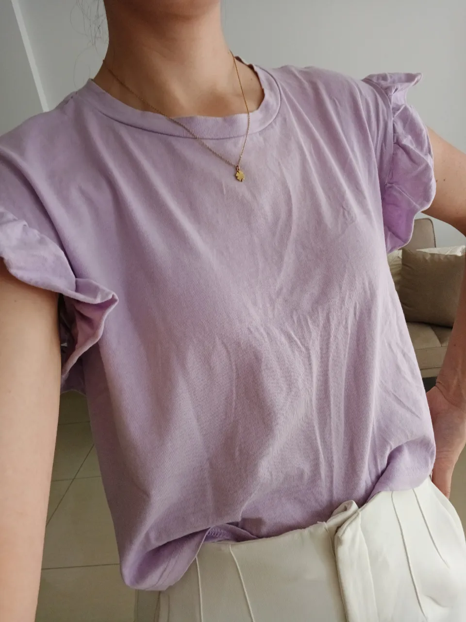 Remera ZARA color lila con mangas cortas con volados. Cuello redondo.