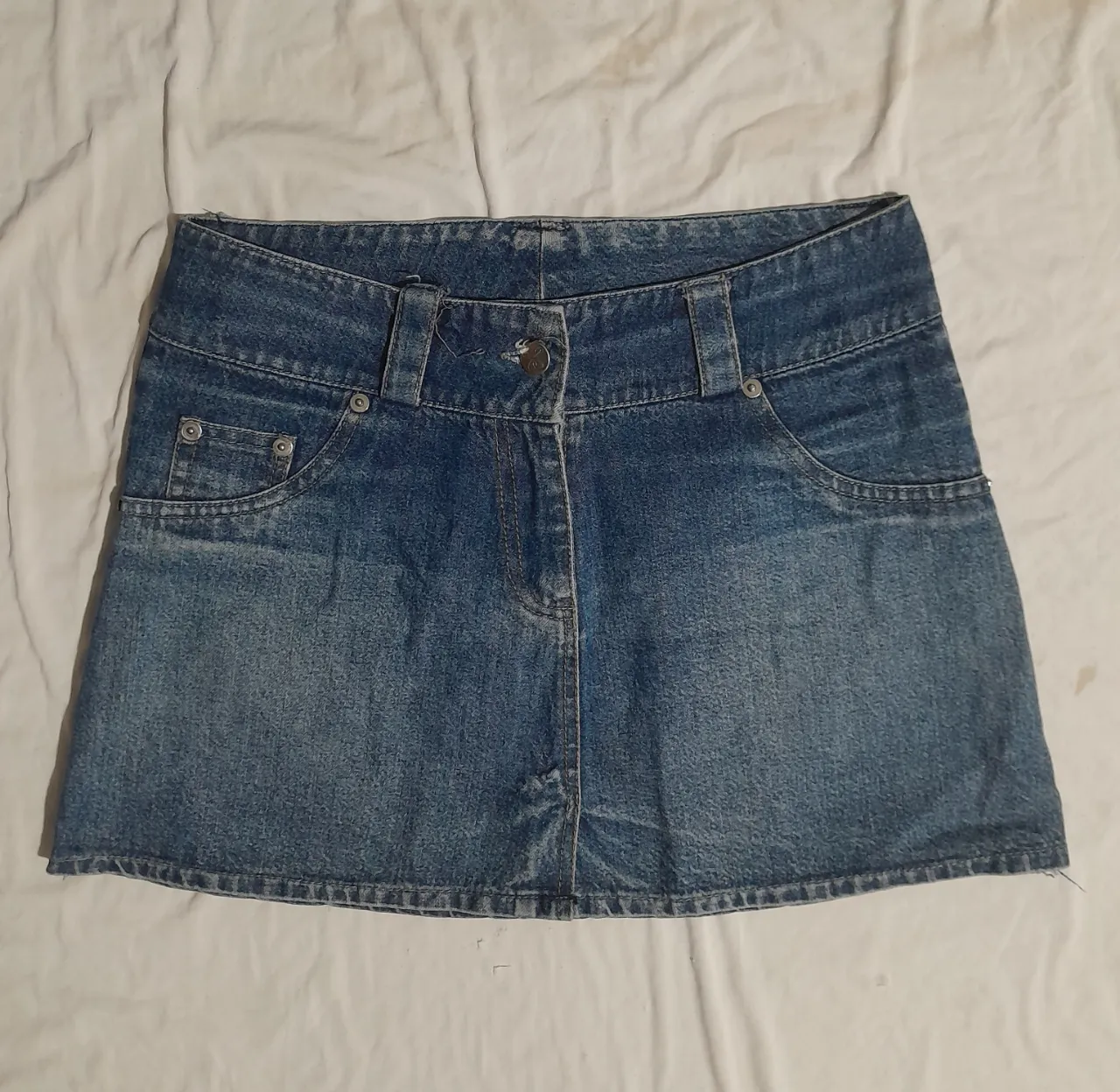 Pollera de jean tiro alto, con bolsillos y detalles desgastados. Un clásico que no puede faltar en tu guardarropa.