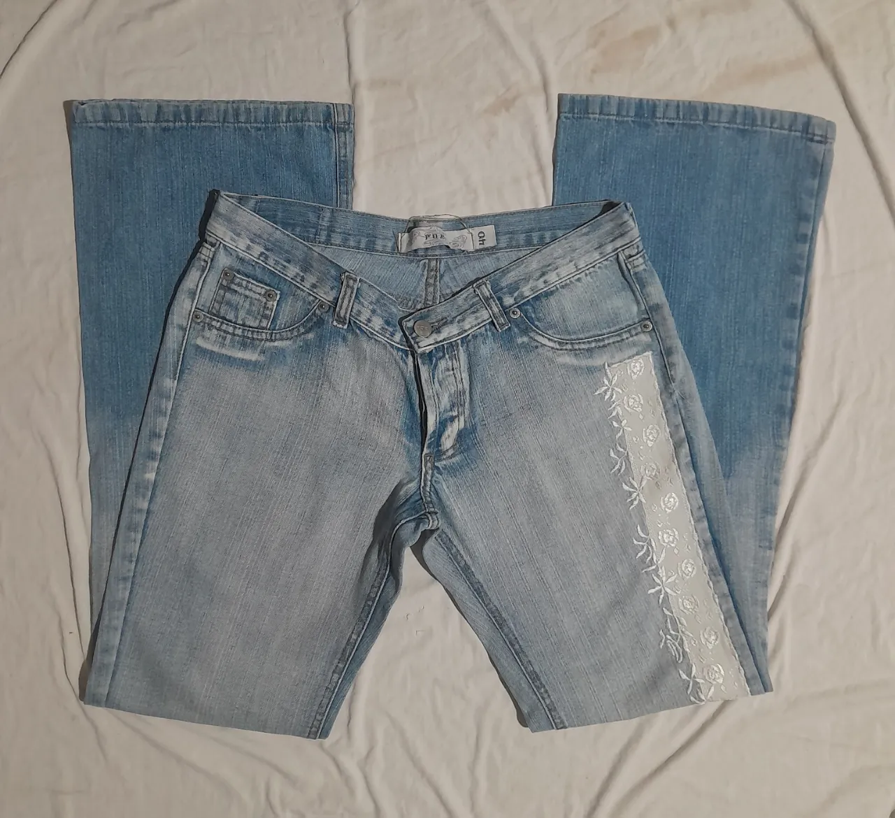 Jeans tiro alto con detalles de encaje blanco en el lateral y un degradado de color en la parte inferior. Un clásico que nunca pasa de moda, ideal para un look canchero y con un toque romántico. Perfectos para combinar con tops o remeras básicas.
Tiene detalles de manchas 