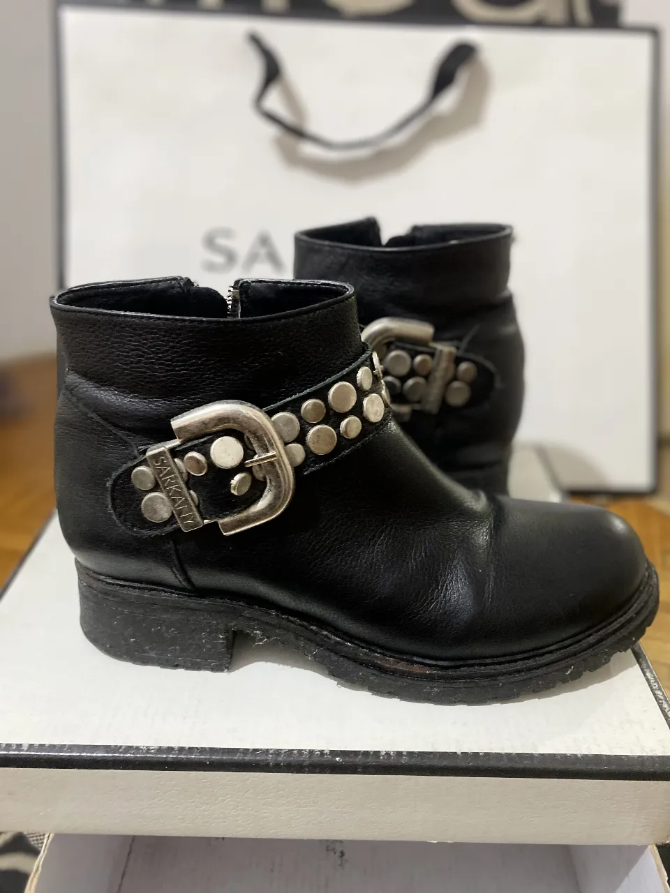 Botitas de cuero negras con hebilla y tachas. Cierre lateral. Estilo rocker.