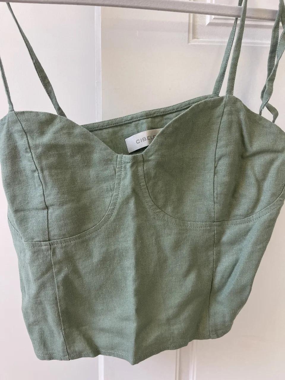 Top de breteles finos con escote en V y detalles de costura en el busto.