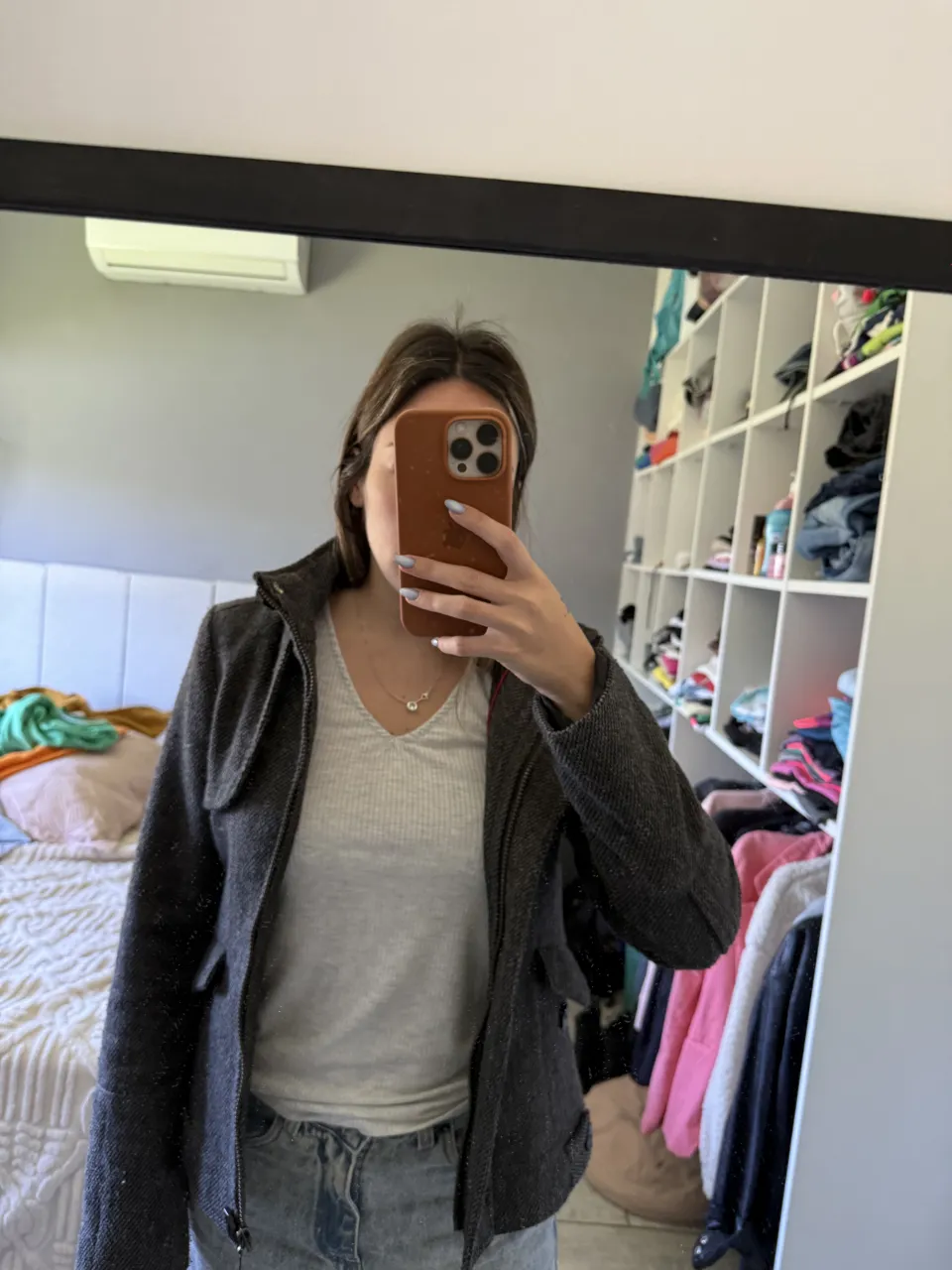 Campera gris con cuello mao y cierre central. Posee bolsillos con solapa y botones en la parte delantera. Interior forrado.