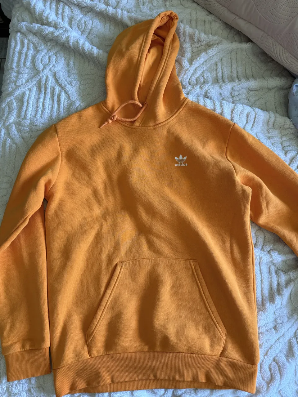 Buzo con capucha de color naranja. Posee cordones para ajustar la capucha y un bolsillo canguro en la parte delantera. El logo de la marca se encuentra bordado en el pecho.

es UNISEX
prácticamente sin uso