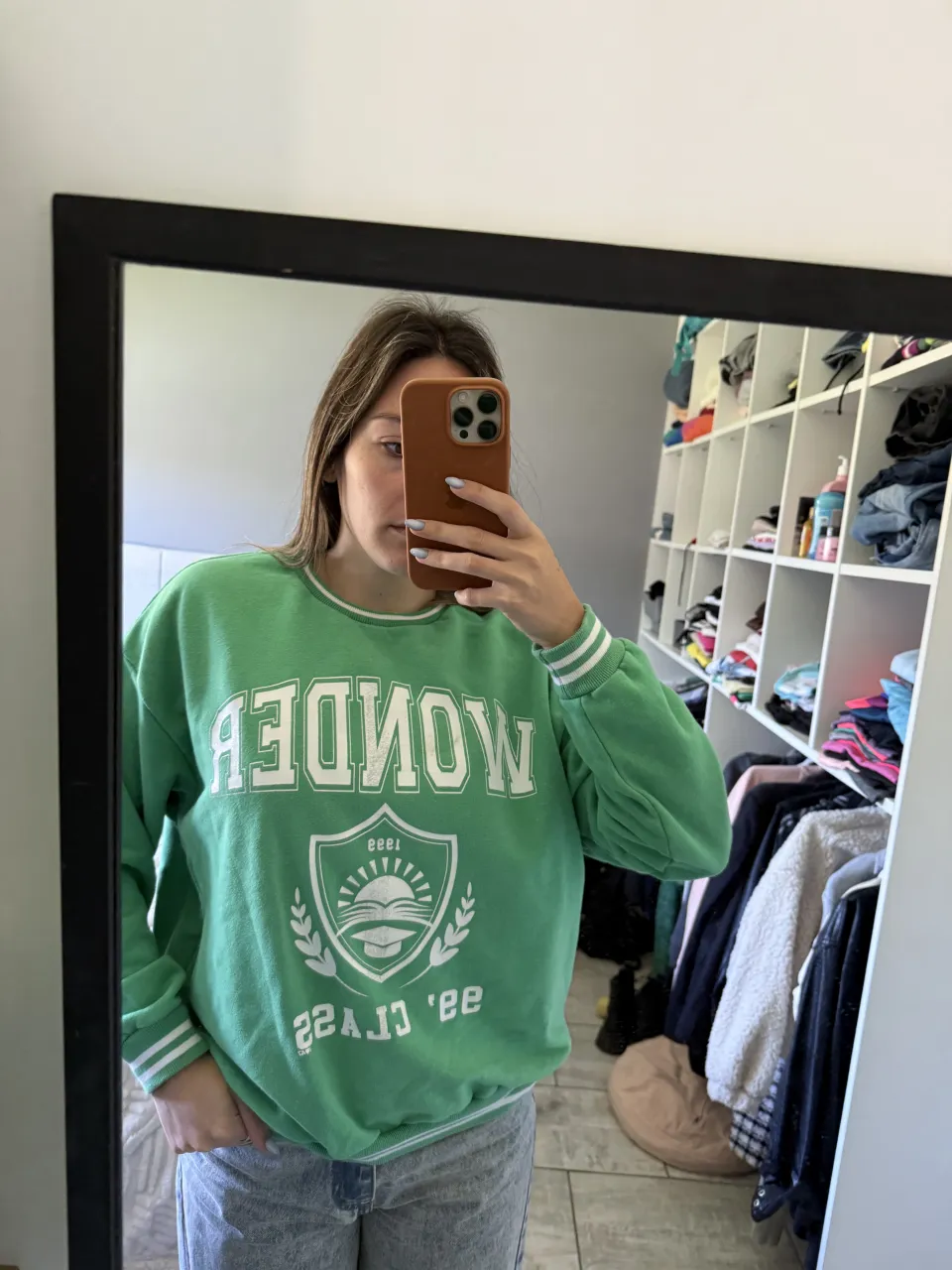 Buzo verde con estampa "Wonder" y escudo con un libro abierto y un birrete. Tiene puños y cuello con detalles de rayas blancas.

vino con el detalle en la estampa ya de fábrica
