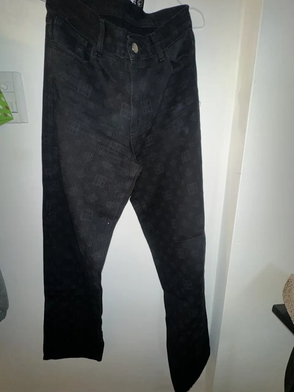Jeans negro con estampado de logos. Corte recto, ideal para un look casual y moderno. Perfecto para combinar con cualquier outfit.