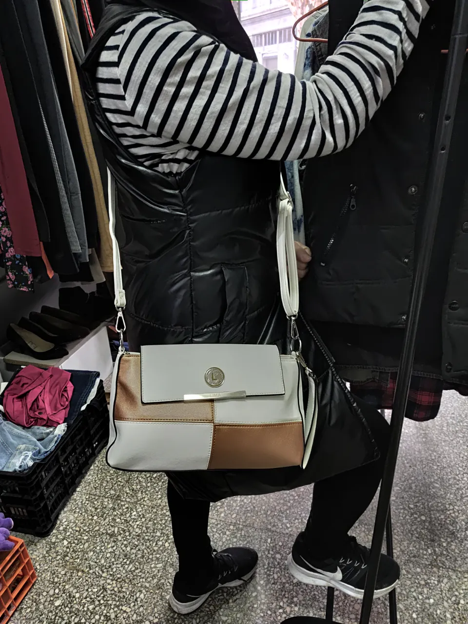Cartera bandolera de diseño moderno, combinando blanco, dorado y marrón. Ideal para un look casual y elegante.