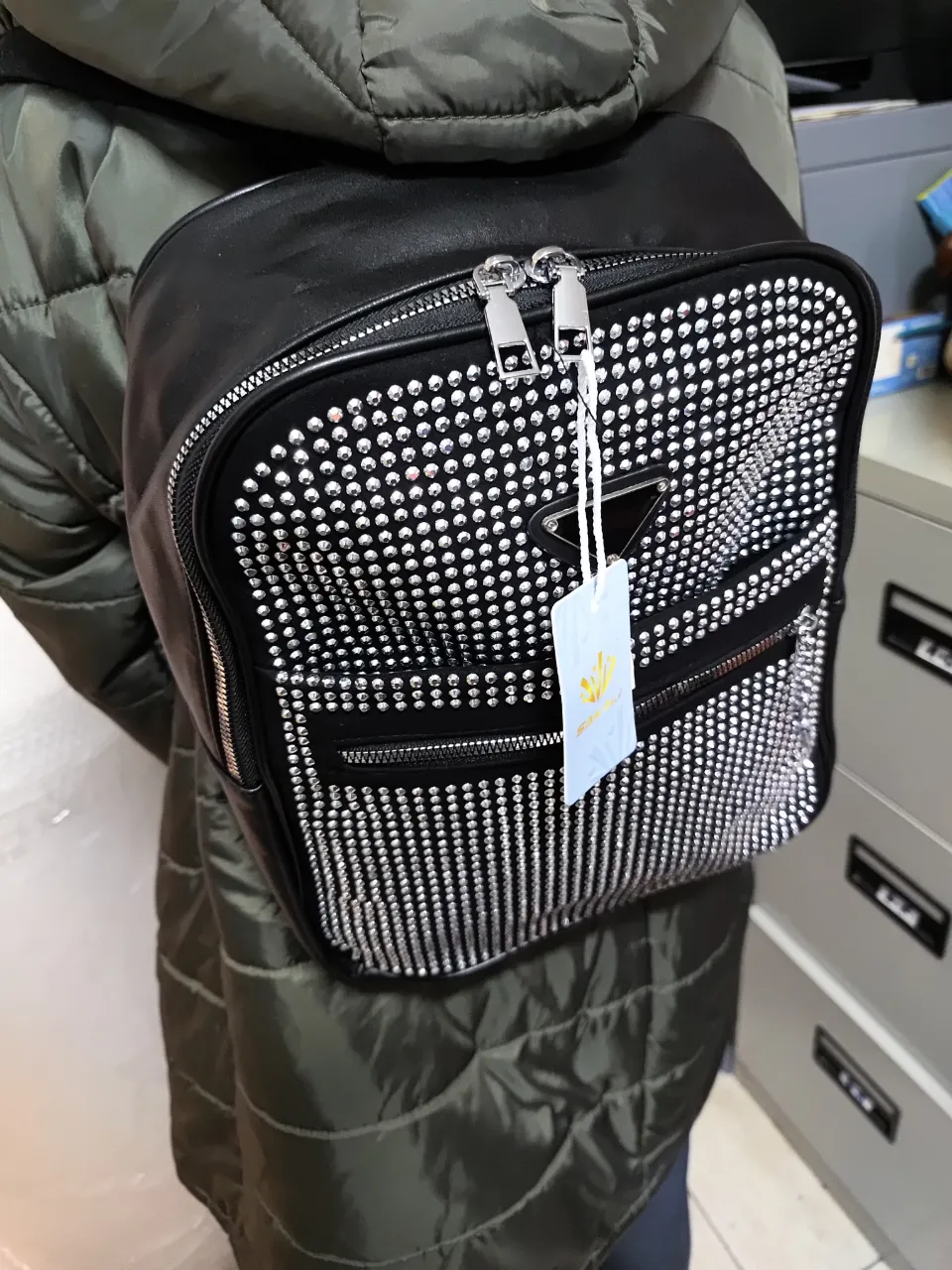 Mochila negra con strass plateados brillantes. Ideal para un look moderno y llamativo. Perfecta para llevar tus pertenencias con estilo. Tamaño mediano.