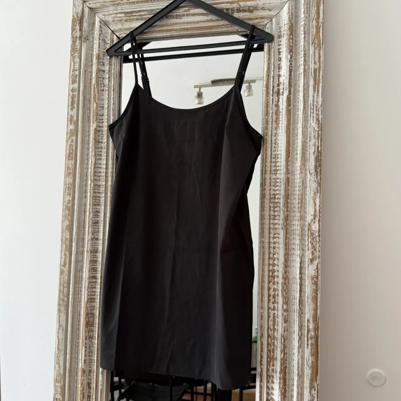 Vestido negro de breteles finos, ideal para usar como base o solo en ocasiones especiales. Su diseño minimalista lo hace súper versátil.