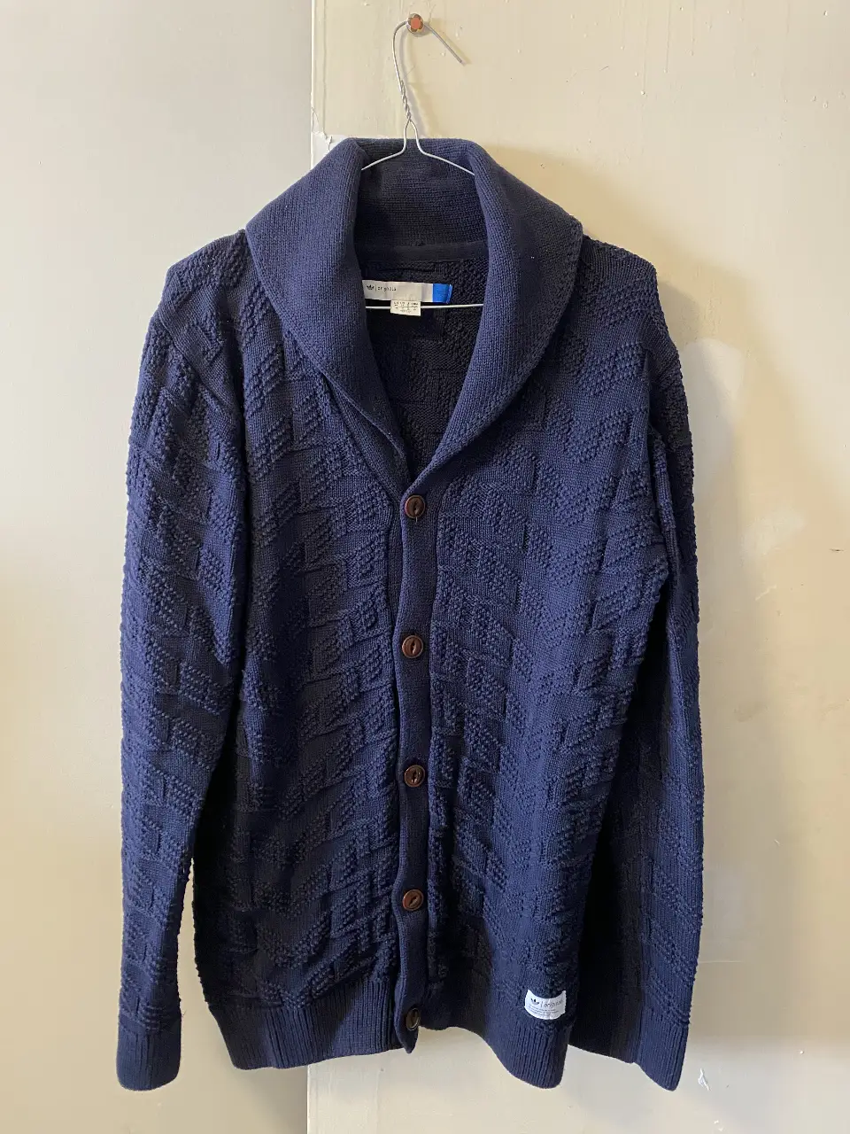 Cardigan de hombre Adidas Originals azul marino con cuello smoking y botones. Tejido con textura.