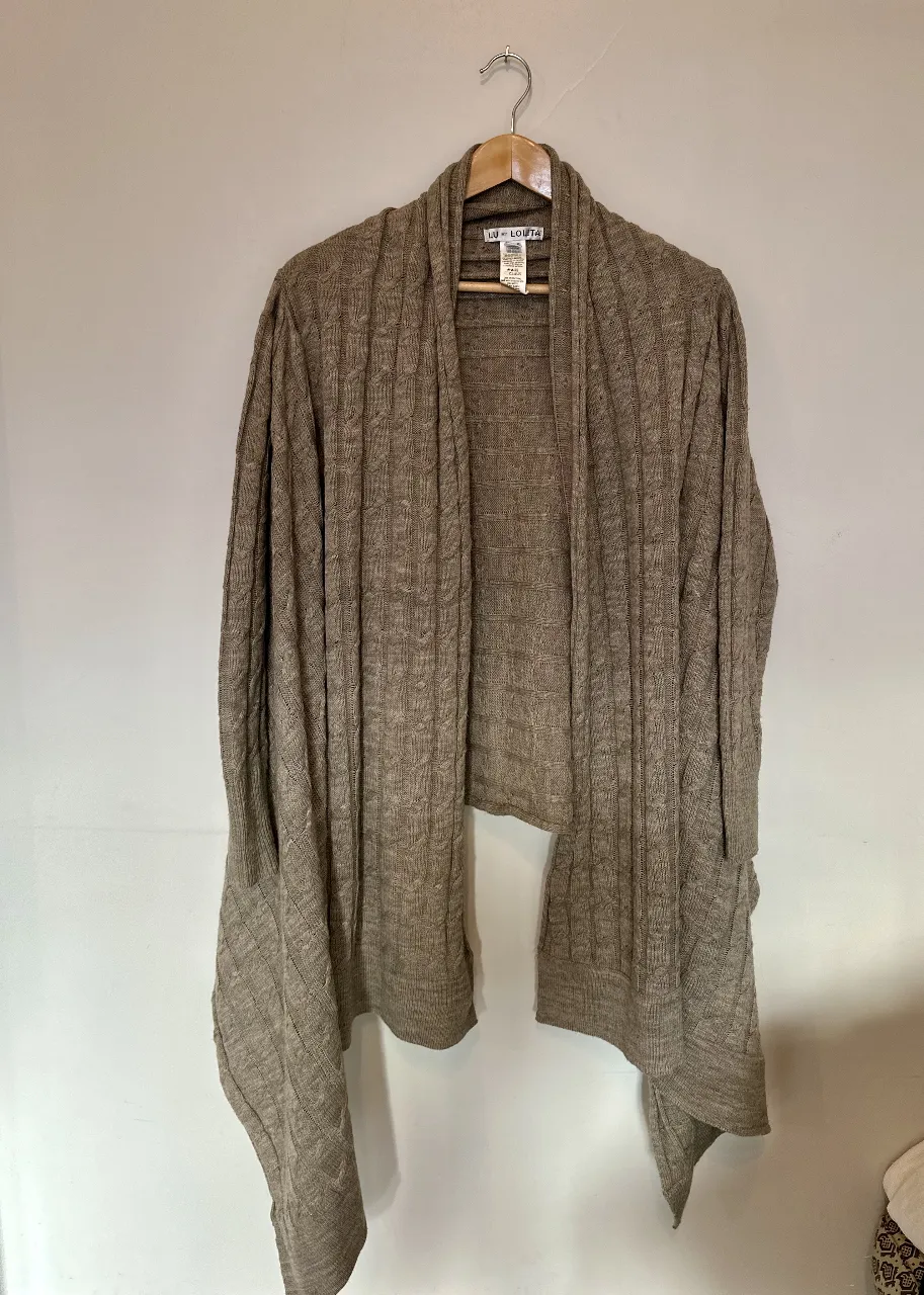 Cardigan tejido de color marrón, con diseño de trenzas y bolsillos. Ideal para un look casual y abrigado.