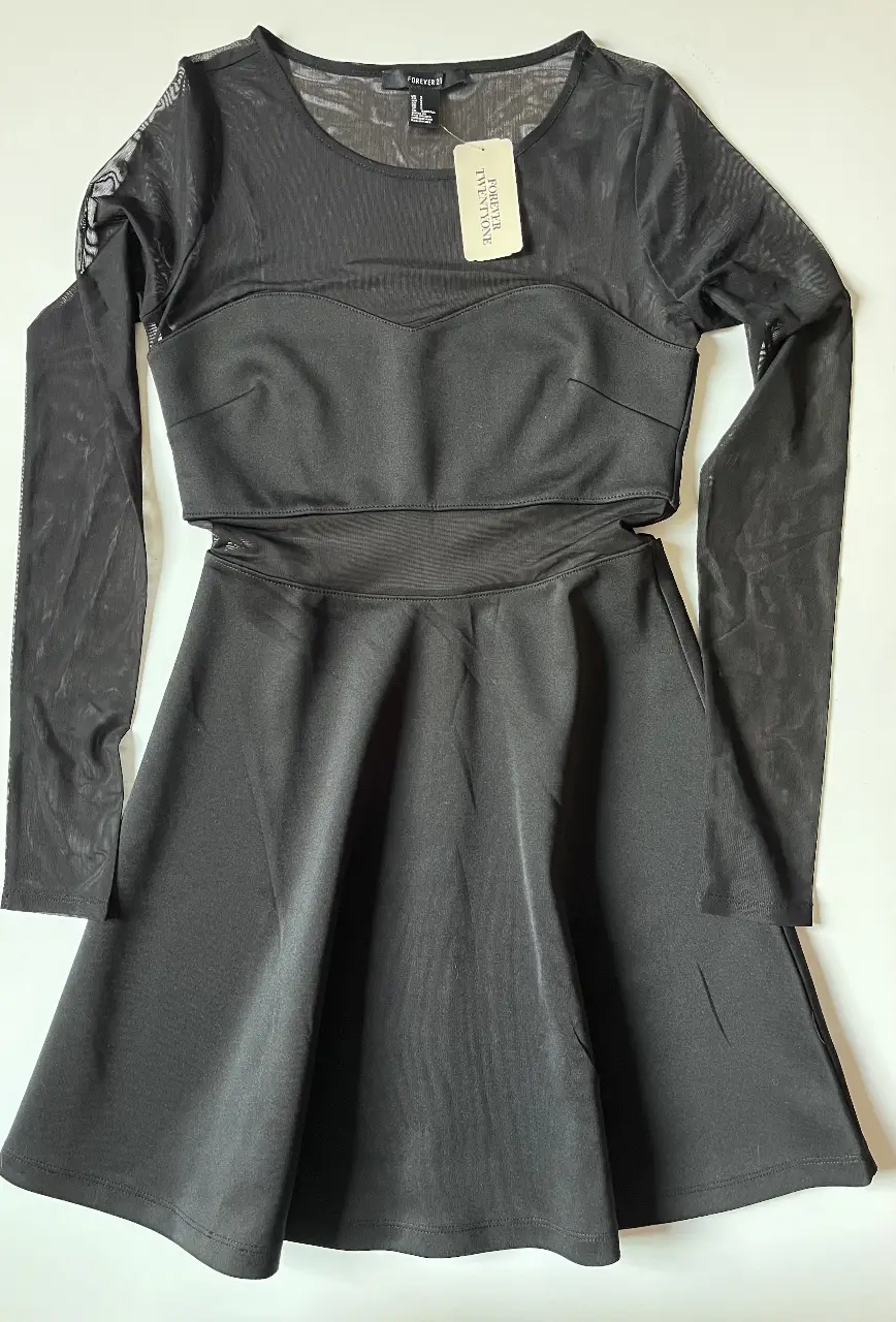 Vestido negro de Forever 21, con mangas largas de red y corte en la cintura. Ideal para una salida nocturna o evento especial.
