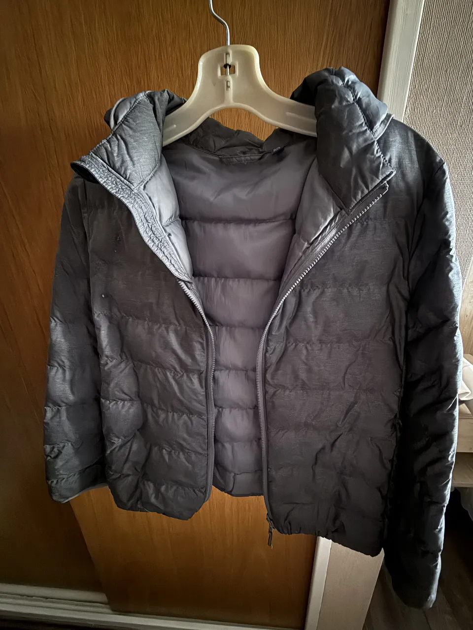Campera UNIQLO de pluma gris, con capucha, cierre y talle 11-12. Ideal para el invierno.