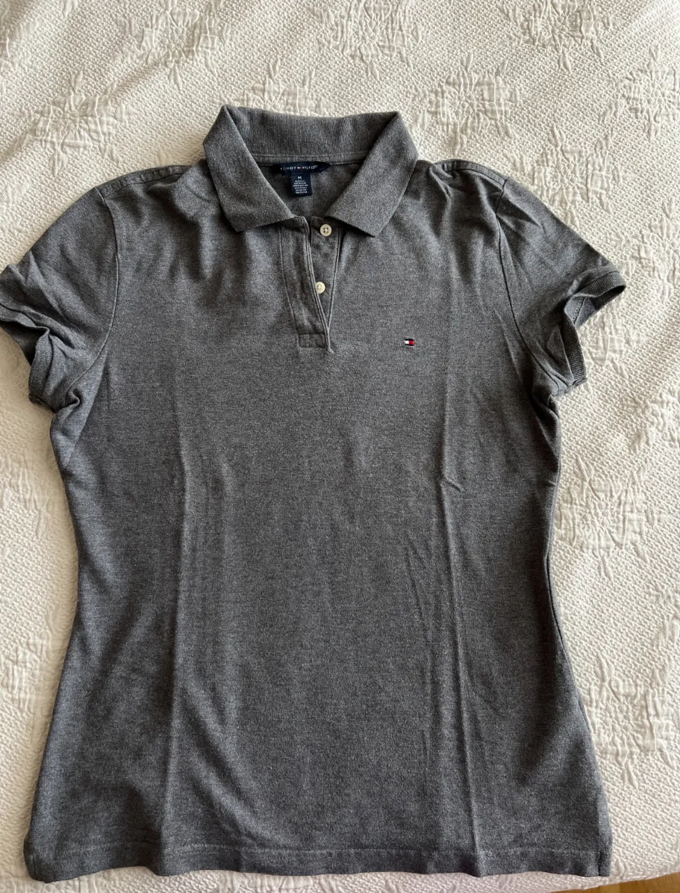 Remera polo gris de mujer, de la marca Tommy Hilfiger, talle M. Ideal para un look casual y cómodo.