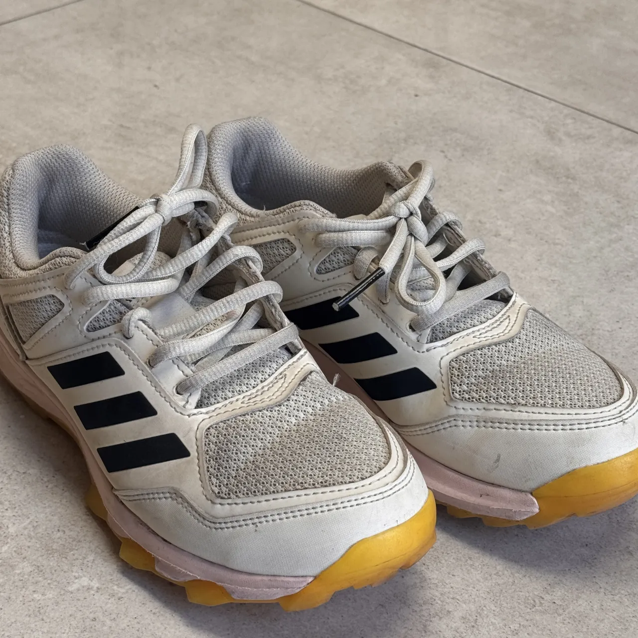 Zapatillas Adidas blancas con detalles en negro y suela amarilla y rosa. Ideales para entrenar o para un look casual. Muy poquito uso! 