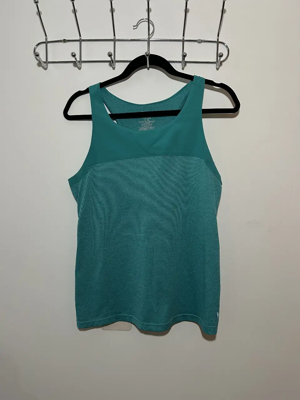 Musculosa deportiva de mujer, color verde, ideal para entrenamientos. Diseño con detalles en la parte superior y espalda.