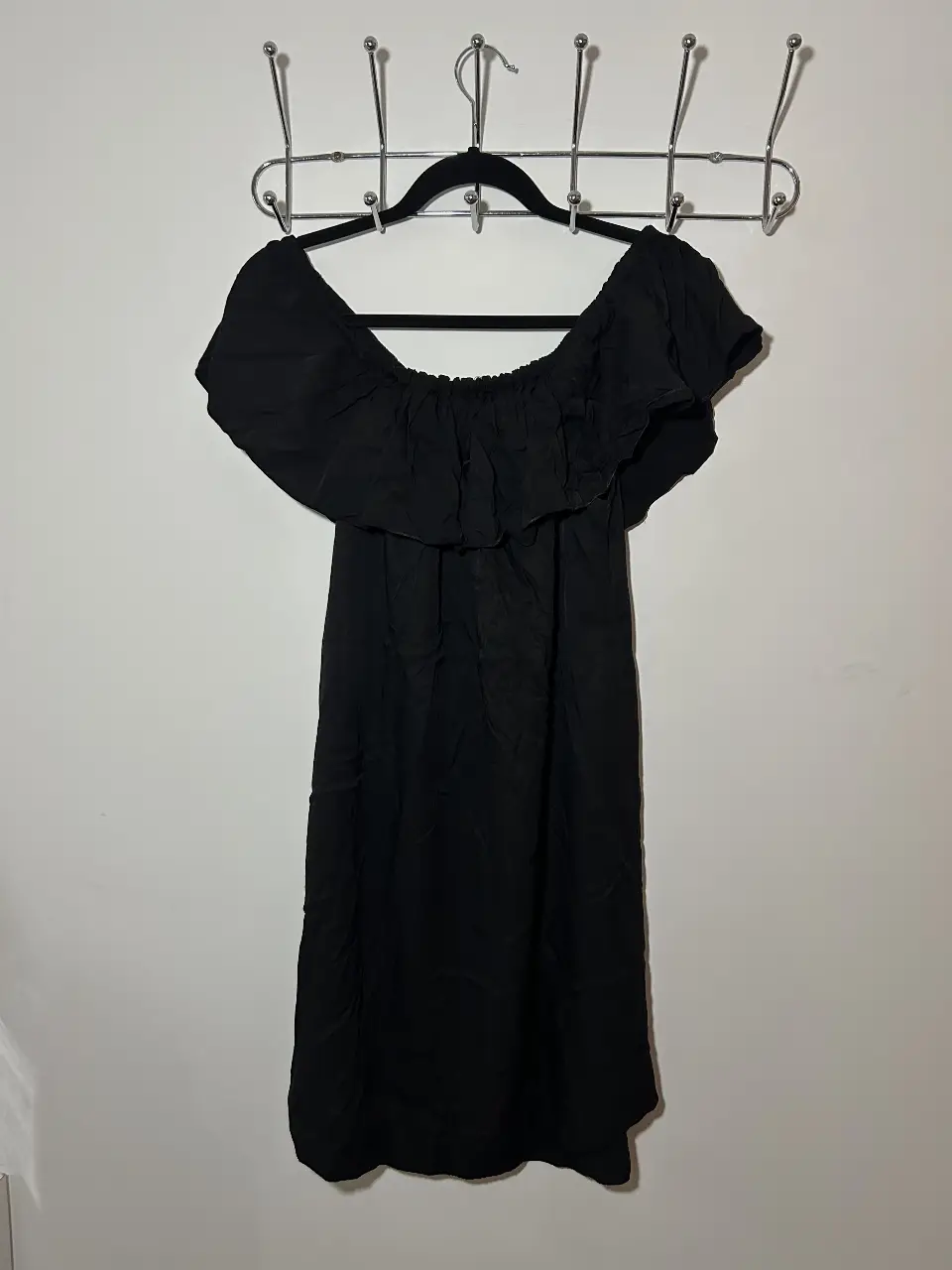 Vestido negro corto, con escote off shoulder y volados. Ideal para una salida o evento especial.