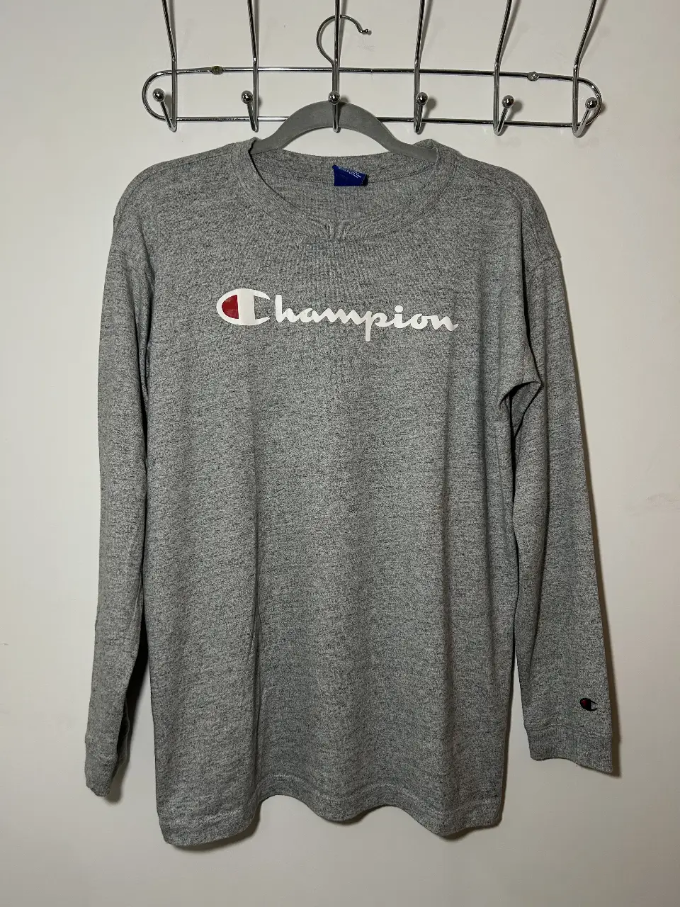 Buzo de cuello redondo Champion gris, con logo estampado en blanco. Ideal para un look casual y cómodo.
