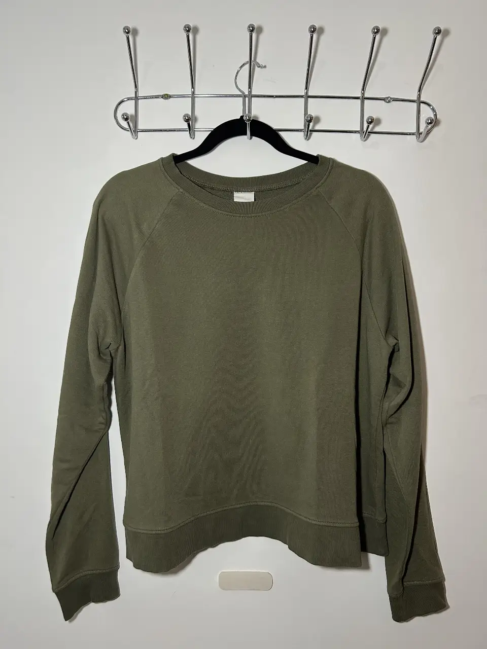 Buzo de cuello redondo en color verde oscuro, ideal para un look casual y cómodo. Perfecto para el día a día.