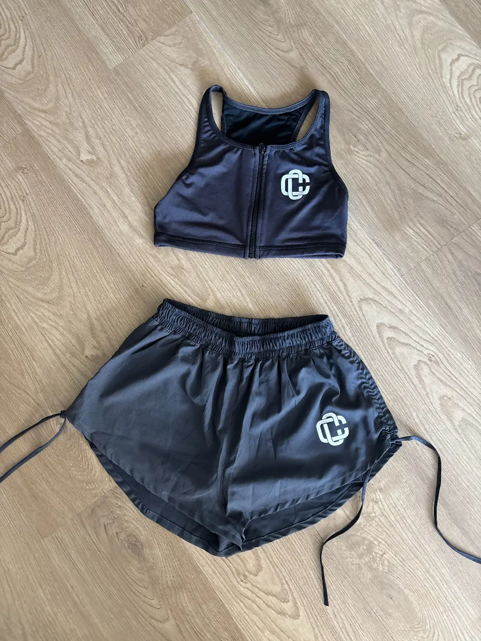 Conjunto deportivo de mujer, top con cierre y shorts con cordones. Ideal para entrenar o para un look casual y cómodo.