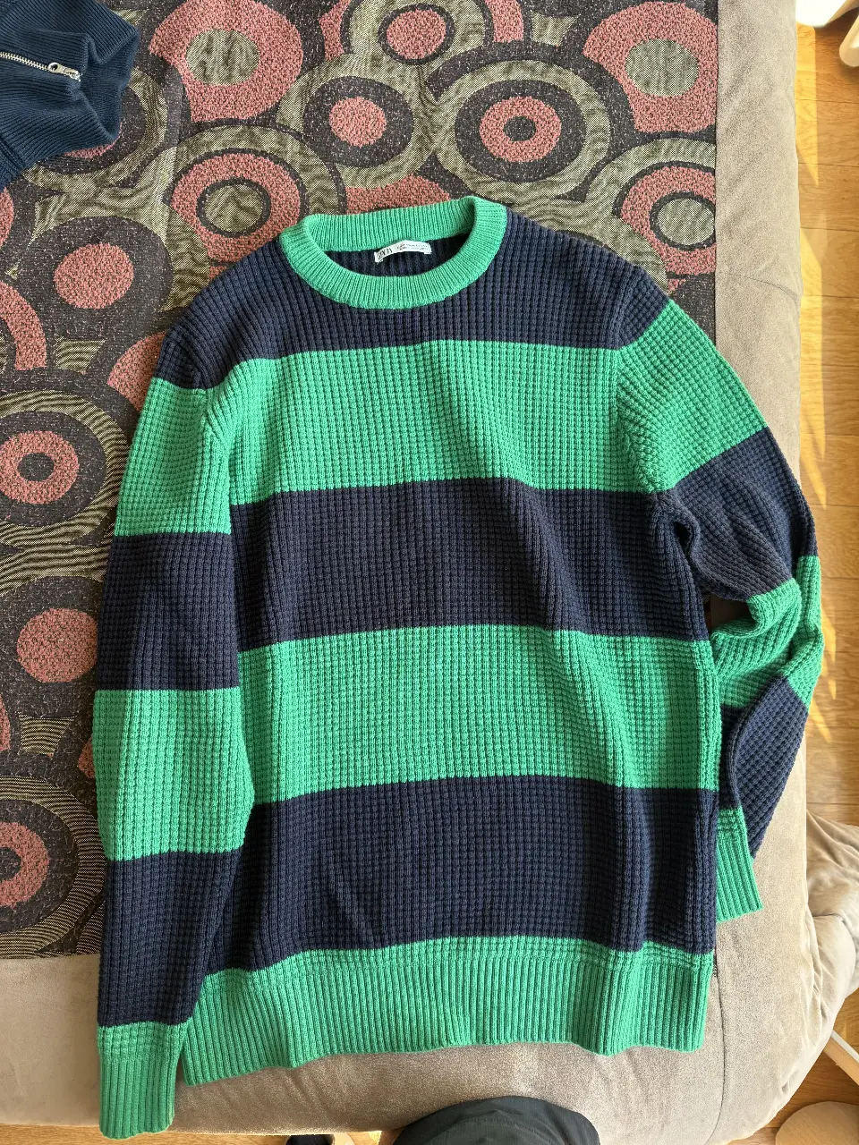 Sweater a rayas horizontales en verde y azul marino, de tejido grueso tipo waffle. Cuello redondo y puños tejidos. Ideal para un look casual y abrigado.