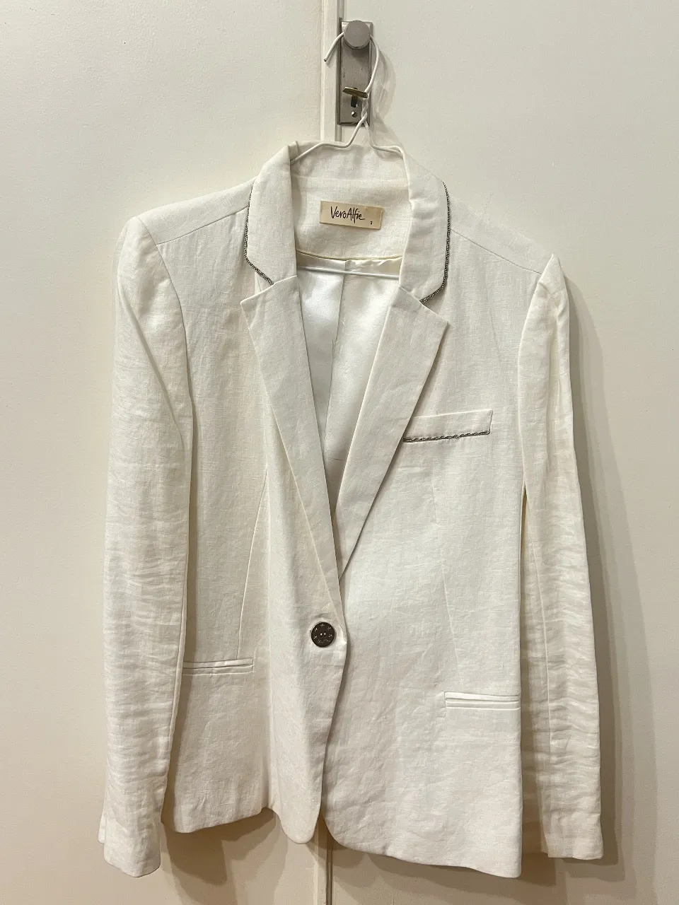 Blazer blanco de lino para mujer, con solapas y un botón. Ideal para un look elegante y fresco.