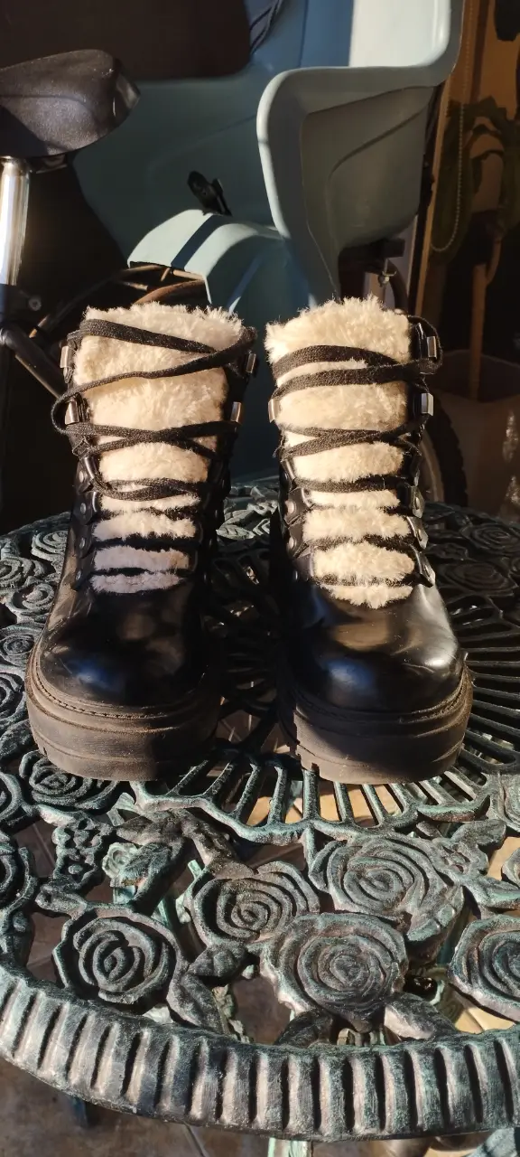 Botines negros con detalles de peluche blanco en el borde superior. Suela gruesa y cordones. Ideales para un look urbano y moderno.