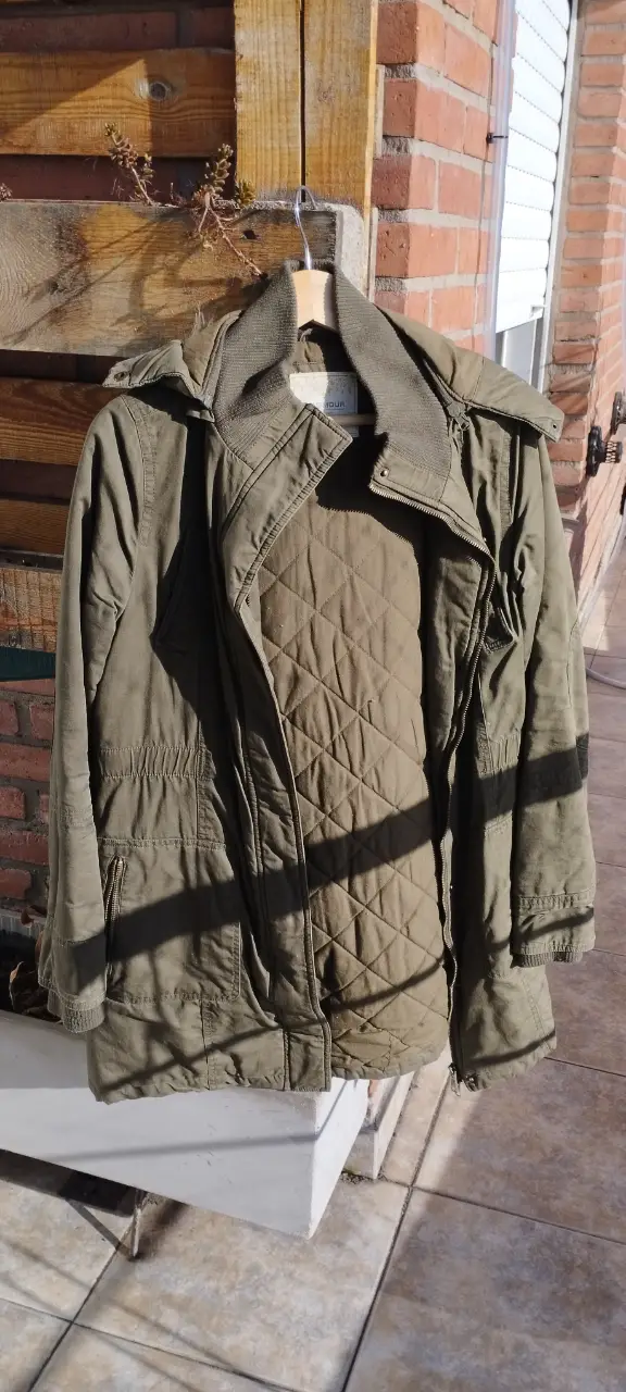 Campera verde militar con capucha y detalles de diseño utilitario. Ideal para un look casual y abrigado.