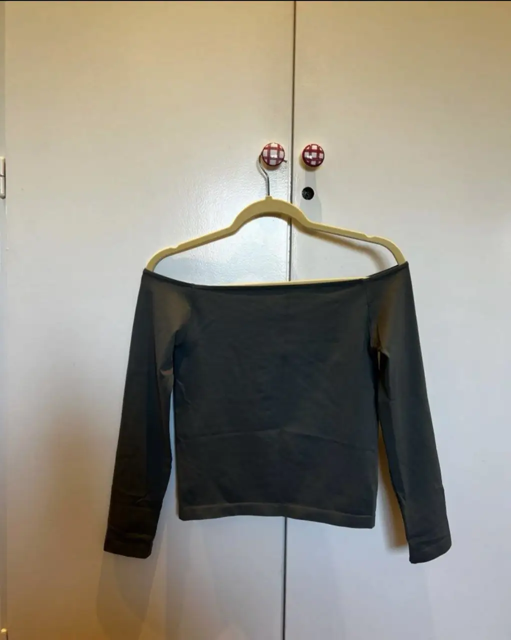 Remera manga larga de mujer, color gris verdoso, con cuello bote y corte ajustado. Ideal para un look casual y moderno. El talle es M-L