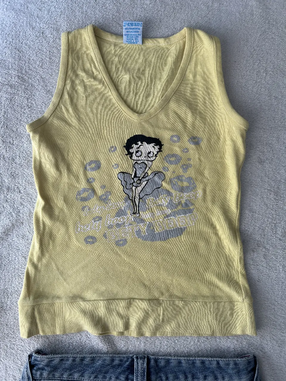 Musculosa amarilla con estampa de Betty Boop y labios. Ideal para un look casual y divertido.
