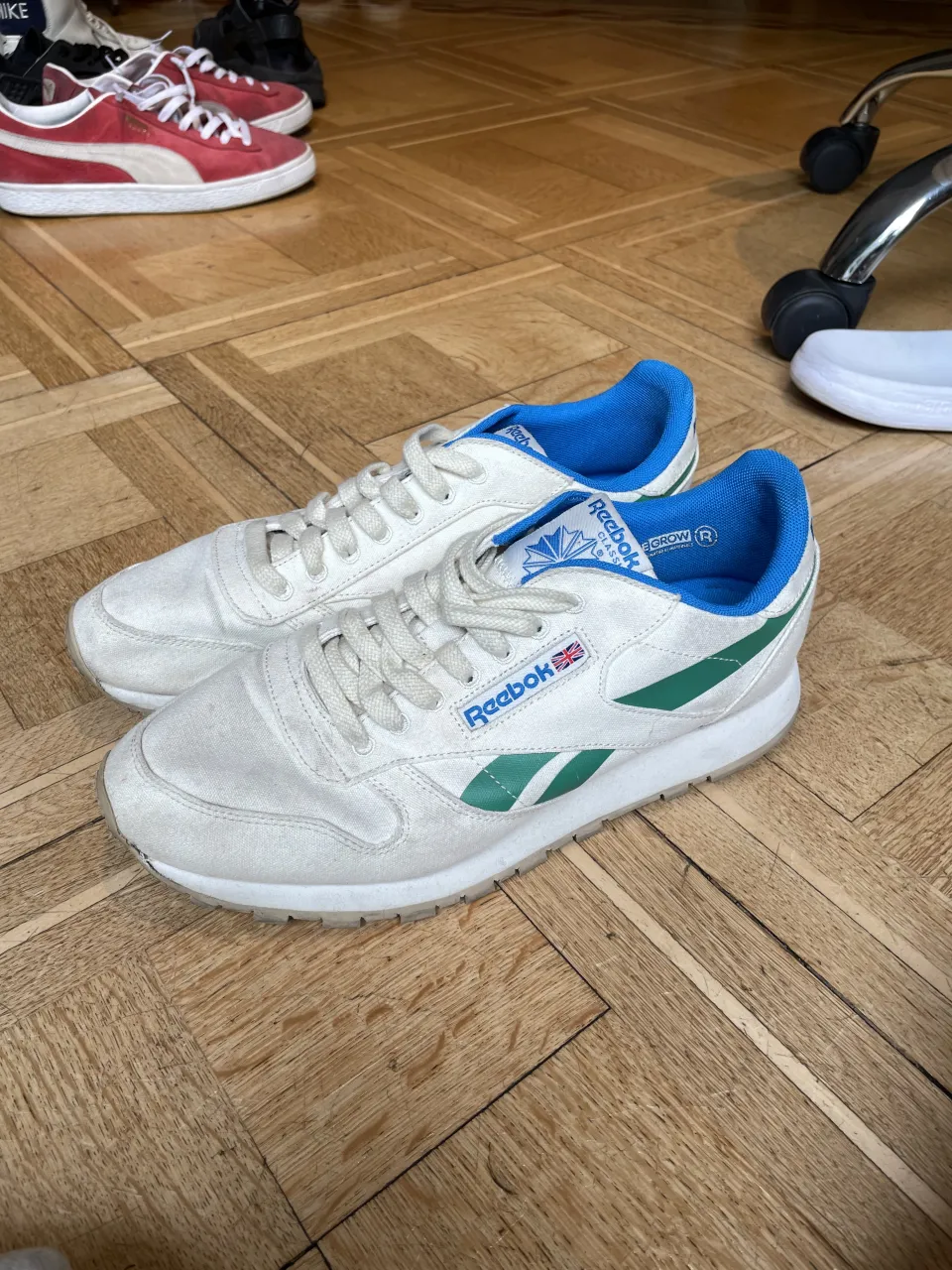 Zapatillas deportivas blancas con detalles en verde y azul. Marca Reebok.