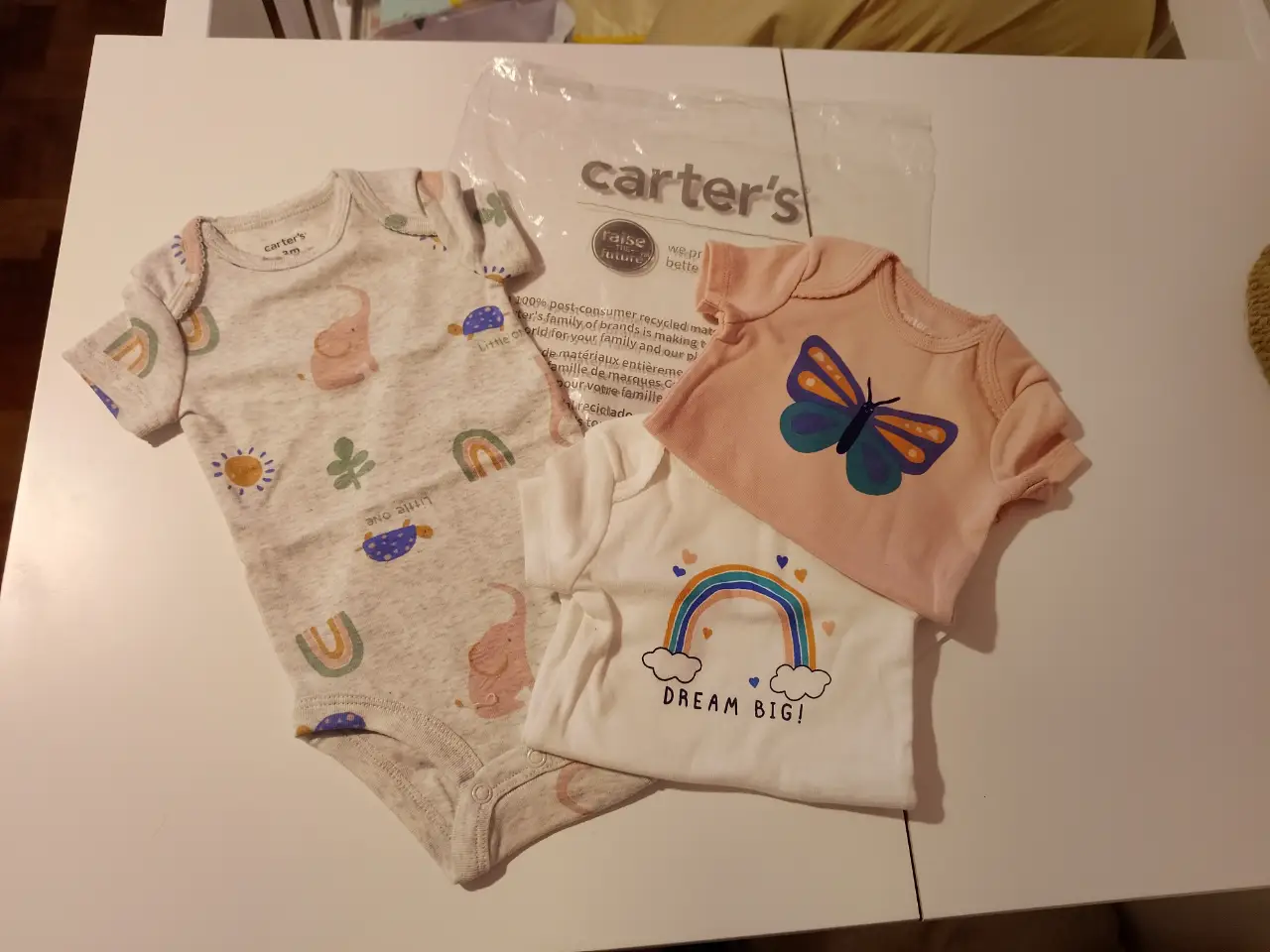 Conjunto de 3 bodies de bebé de la marca Carter's. Incluye tres bodies de manga corta con estampados de animales y arcoíris.