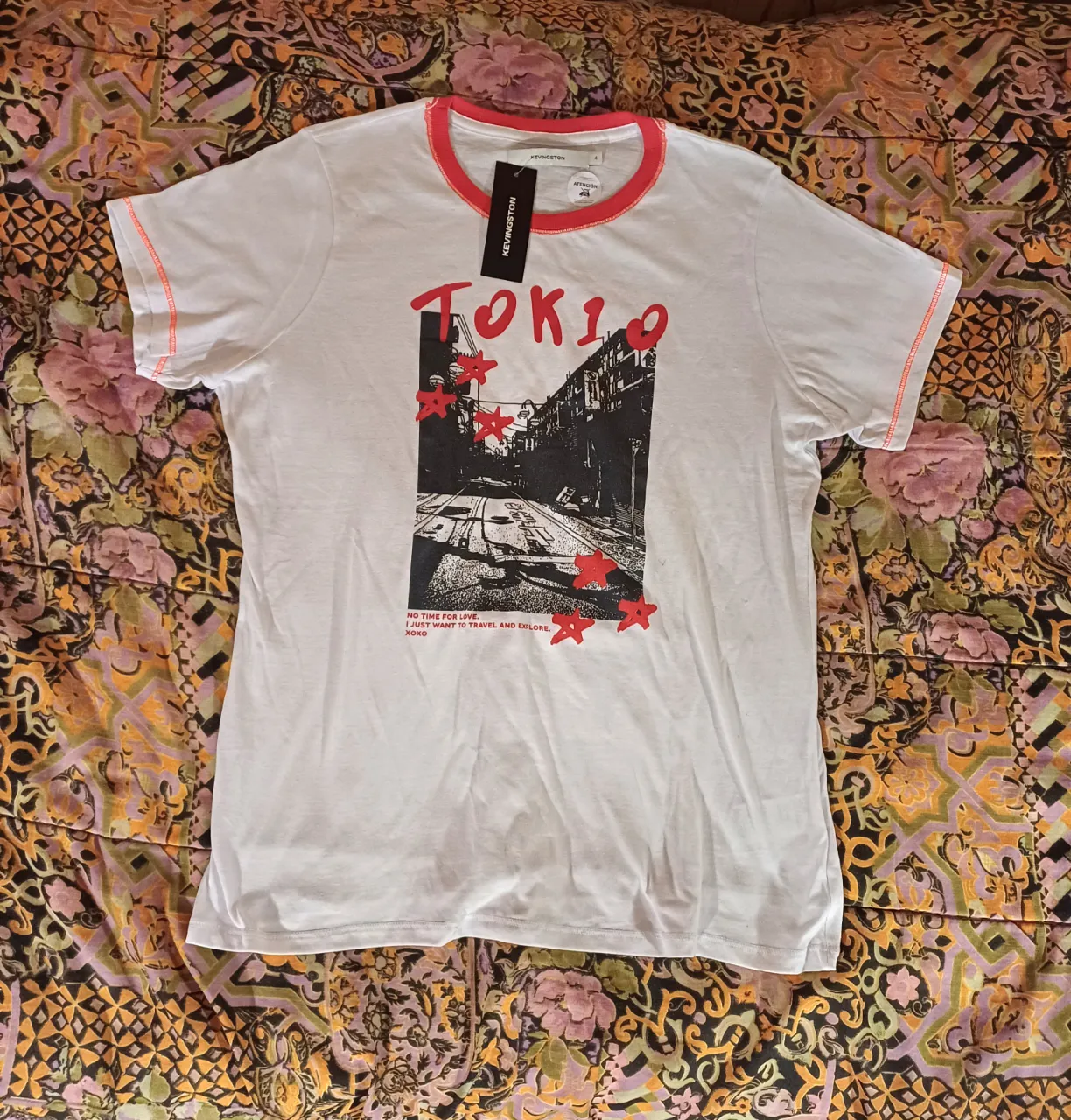 Remera blanca de manga corta con cuello redondo y detalles en rojo. Presenta un estampado frontal de una calle de Tokio con la palabra "TOKIO" en letras rojas y estrellas rojas. En la espalda, tiene "XOXO" escrito con strass rojo. Ideal para un look casual y urbano.
Talle S/M, medidas:
sisa a sisa: 50 cm
largo: 66 cm