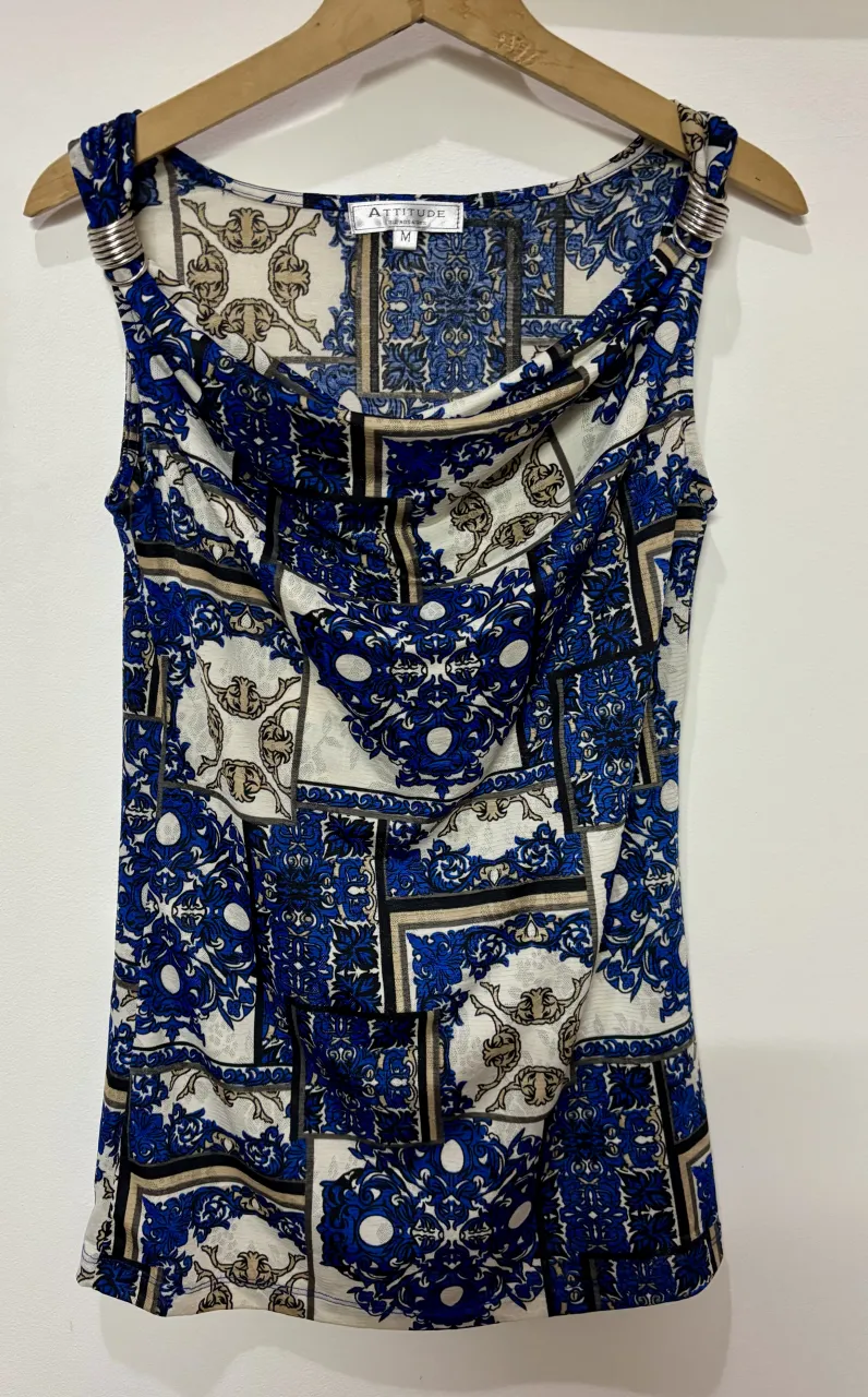 Blusa estampada con detalles metálicos en los hombros. Diseño vibrante y moderno, ideal para un look canchero y fresco.