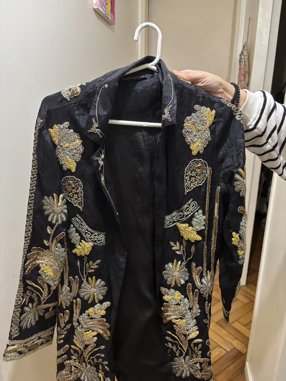 Elegante blazer negro con bordados dorados y detalles en otros colores. Ideal para eventos especiales o para darle un toque sofisticado a tu look diario. Perfecto para mujeres que buscan una prenda única y con estilo.