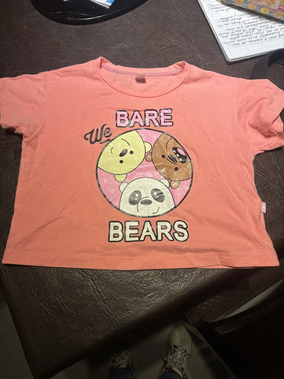 Remera de manga corta para niña, color rosa. Estampado frontal de los personajes de "We Bare Bears" en un círculo. Ideal para un look casual y divertido.
