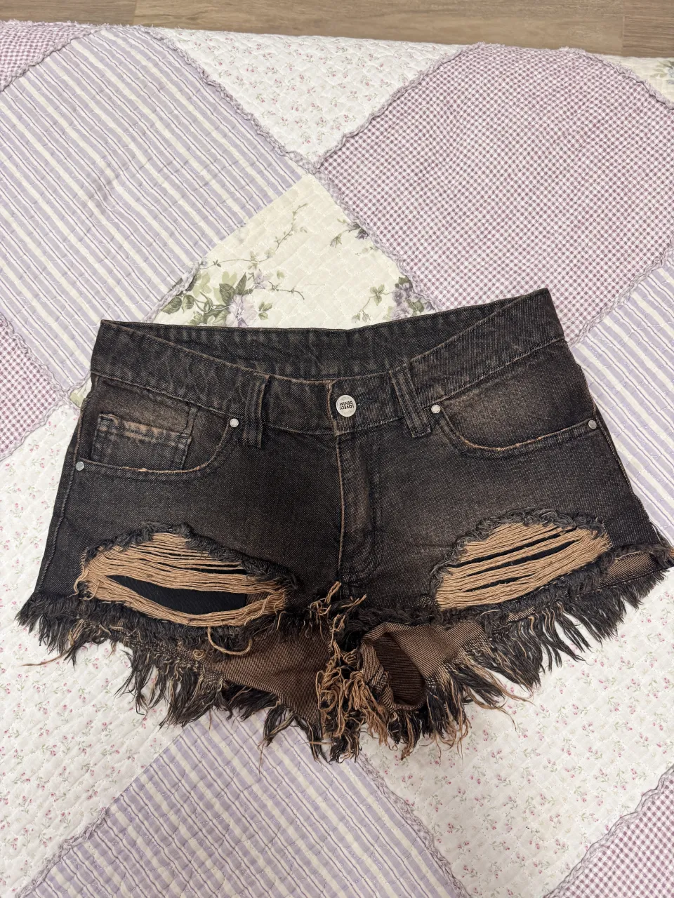 short de jean marca lovely denim TALLE 22, marron y negro con roturas y flecos. tiene bolsillos delanteros y traseros. usado 2/3 veces.