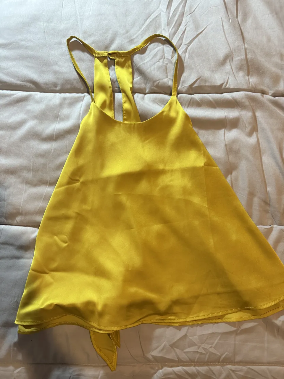 Top amarillo con tiras finas y lazo en la espalda.