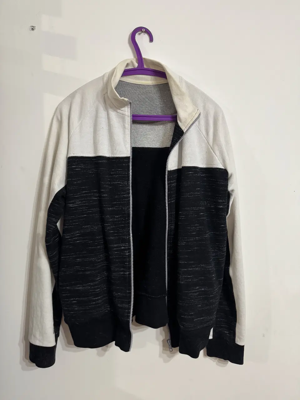 Campera con cierre para mujer de color blanco y negro. Confeccionado en algodón y poliéster, ideal para un look casual y cómodo.